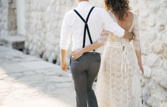 Bride and groom walk along the old pavements of the town. Bottom view.