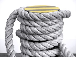 Iron mooring post with a thick rope wrapped around it