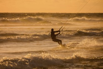 Single surfer at sunset on a calm ocean