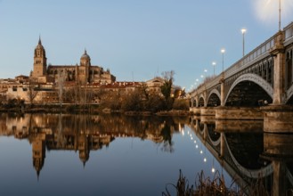 Scenic view of Salamanca with the Cathedral and iron bridge reflected in the Tormes River at sunset