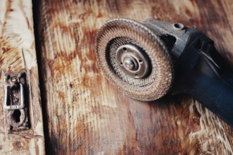 Close-up of an angle grinder on a textured wooden surface
