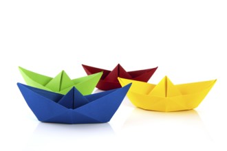 Colorful folded paper boats isolated over white background