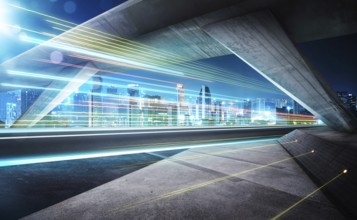 Empty asphalt road under the bridge during the night with light trails and beautiful city skyline