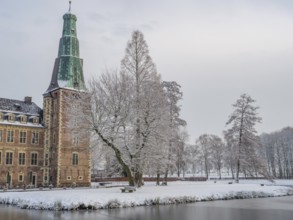 Snow-covered castle and lake in winter with trees and historic architecture, Raesfeld, münsterland,