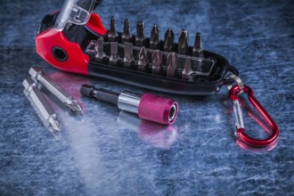 Turnscrew with interchangeable heads on scratched metallic background construction concept