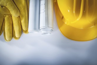 Construction drawings hard hat protective gloves on white background