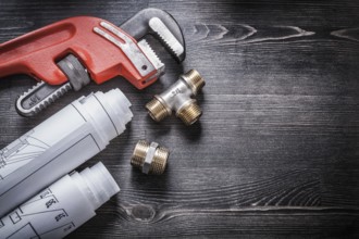 Monkey wrench copper plumbing fittings rolled up construction plans