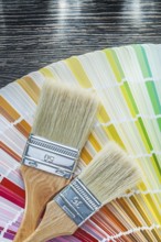 Color pantone fan paint brushes on wooden board top view