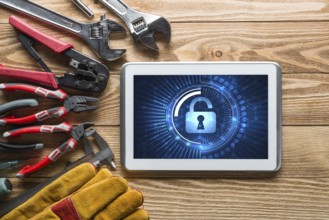 Tablet pc with security concept on screen and industrial tools around