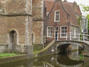 Historic brick building on a canal with small bridges and green surroundings, Delft, Netherlands