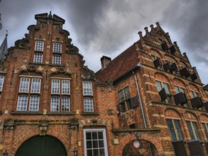 Historic brick houses with ornate facades, dramatic clouds in the sky, zutphen, gelderland,