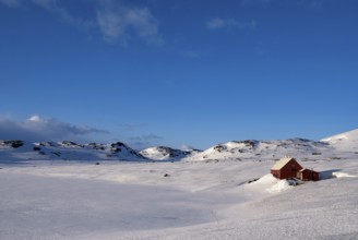 Wooden house on the snowcovered Norwegian mountain plateau Hardangervidda