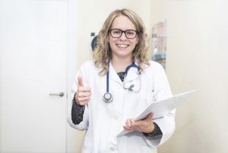 Portrait of a young female doctor showing thumbs up, positive emotion