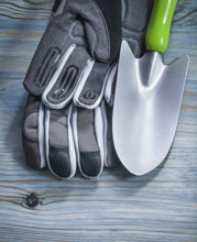 Safety gloves hand shovel on wooden board gardening concept