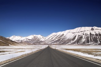 View of the long and straight panoramic road leading to Castelluccio di Norcia in central Italy