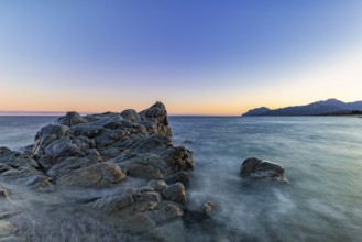 Rocks in the sea on the beach of Torre di Bari at sunset, long exposure, Torre di Bari, Bari Sardo,