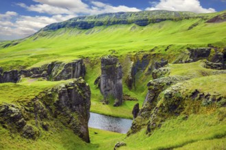 Bizarre shape of cliffs surround the stream with glacial water. The striking canyon in Iceland. The