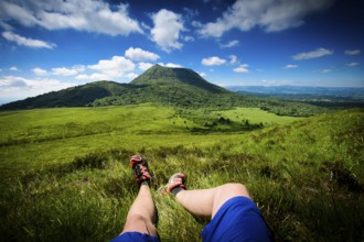Puy de Dome mountain and hikers legs in Auvergne in France