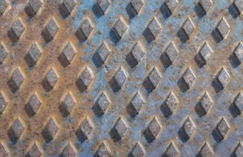 Old rusty drain cover background with diamond pattern