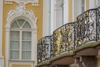 Detail of a richly decorated façade and ornate balcony railing on a historic building, saint