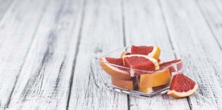 Chopped Grapefruits (selective focus) on a vintage background as detailed close-up shot