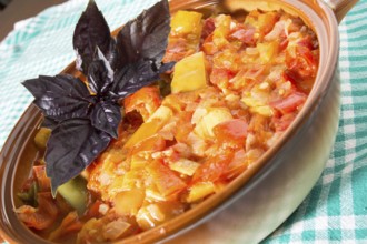 Closeup of delicious stew with mixed vegetables, arranged with green and purple leaves