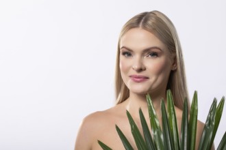 A woman elegantly poses with a lush aloe vera plant, showcasing the essence of natural beauty and