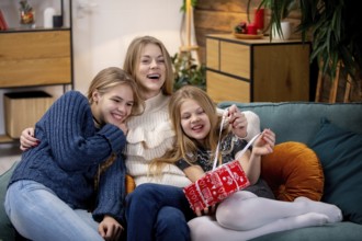 Three happy kids are joyfully sharing a playful moment on a cozy sofa, capturing the essence of