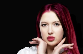 Beautiful girl model with sensual lips and red hair on a black background