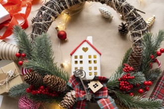 Key to the house with a keychain on a cozy home with a Christmas decor layout. A gift for New Year,