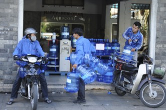 Vietnam/Saigon: Water supply by motorbike courier. water-supply with motorbike-taxi
