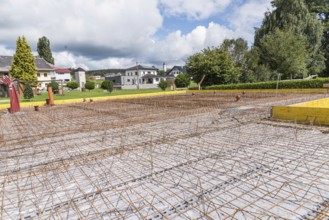 House construction site with steel grid for concrete foundation slab, construction industry