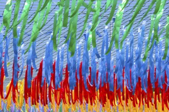 Close up shot of decorative multicolor ribbons waving in the wind at city street holiday, festival