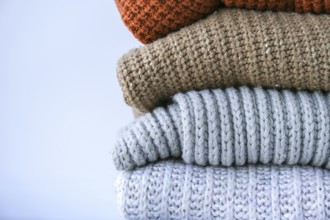 Stack of cozy knitted warm sweater. Sweaters in retro Style. Orange and blue colors. Cozy hygge