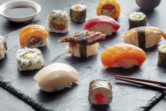 Sushi with chopsticks. Rolls, maki, nigiri on a black background, Japanese food. Salmon, tuna, eel,