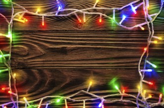 Christmas lights on dark wooden background flat lay mockup frame for greeting card