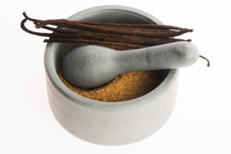 Brown vanilla sugar and vanilla beans in mortar