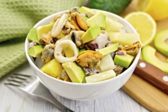Salad with shrimps, octopus, mussels and calamari with avocado, lettuce, lemon and pineapple in a