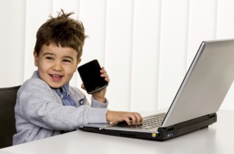 Little boy at the laptop, symbol for internet, e-commerce, consumer behaviour