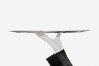 Waiter with white hemp shoes carries a silver tray