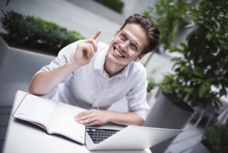 Happy handsome businessman mixes his break and job outdoors, businessman with headphones write some