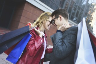 Portrait of a couple with shopping bags in the city.People, sale, love and happiness concept