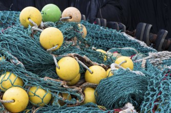The photo shows a pile of fishing nets with floats