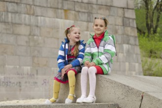 Two girls of four and six years of walking on the embankment of the river