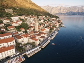 Perast promenade with outdoor restaurants on the piers by the sea. Montenegro. Drone.