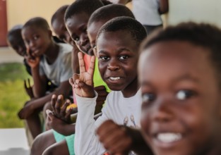 Children making a peace sign with their hands. Snapshot. It was taken during a rubbish collection