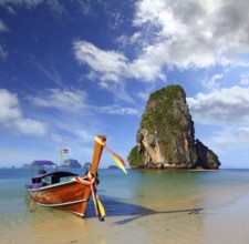 Long tail boat on tropical beach (Pranang beach) and rock, Krabi, Thailand, Asia