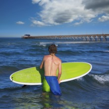 Boy surfer waiting for the waves on Newport pier beach California