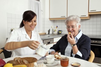 A geriatric carer helps a senior citizen with breakfast. Caring for senior citizens Austria