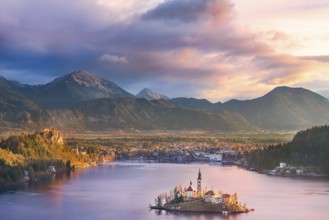 Colorful sunrise over the Bled lake, its surrounding hills, its island and the Karawanks mountains